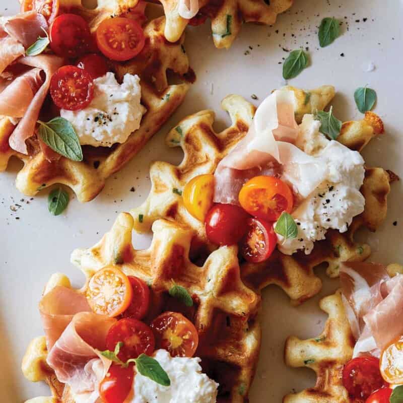 Cheesy herb waffles topped with prosciutto, burrata and tomatoes.