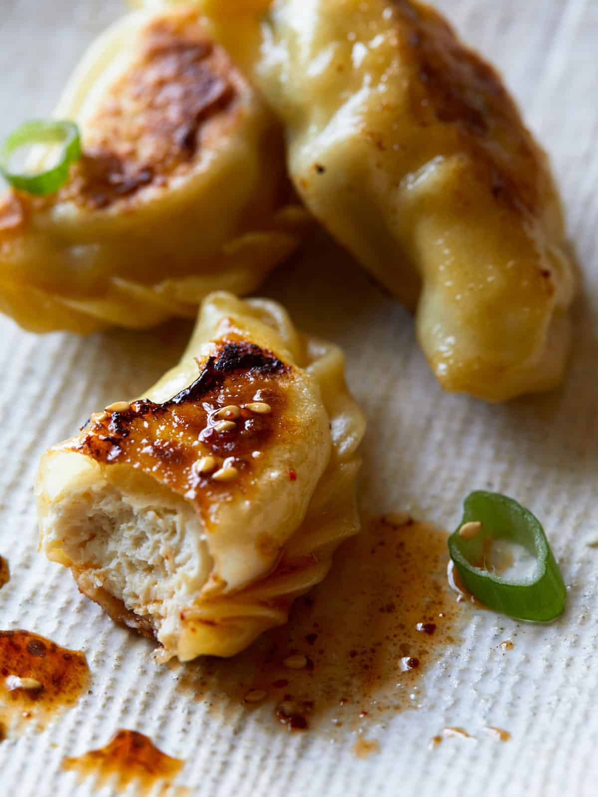 A close up of crispy chicken potstickers with green onions.