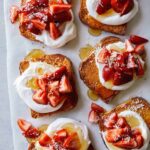 Honey brick toast topped with whipped cream and strawberries.