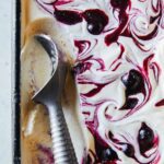 A close up of blueberry vanilla honey swirl semifreddo with ice cream scoop.