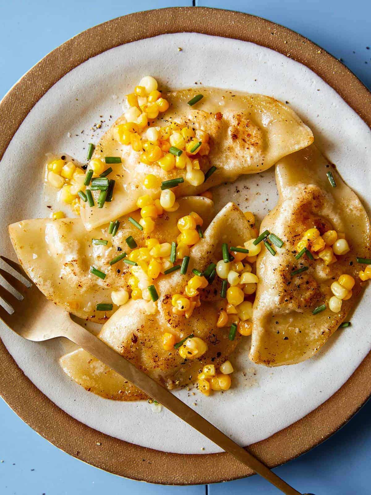 Creamy shrimp and corn ravioli on a plate with a fork.