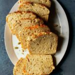 Slices of cheesy herb beer bread on a white plate.