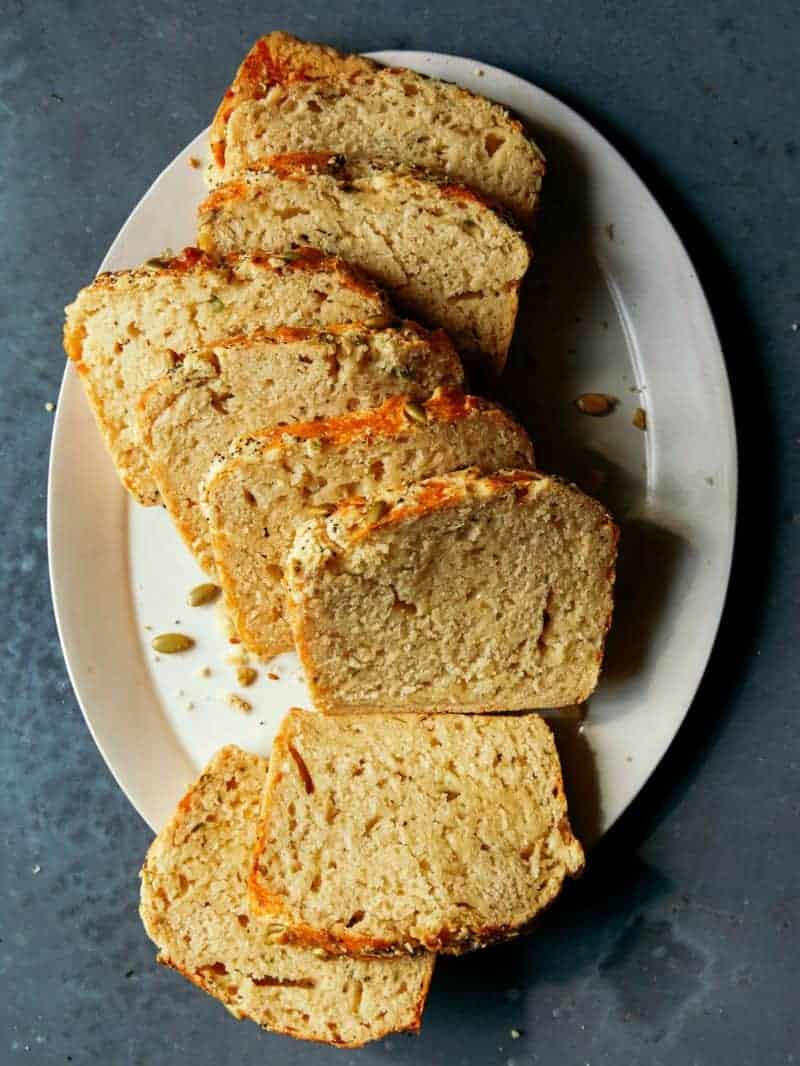 Slices of cheesy herb beer bread on  a white plate.