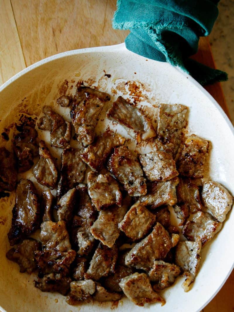Cooking strip steak in a skillet to make Mongolian Beef. 