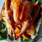 A close up of a citrus dry brined turkey on a platter.