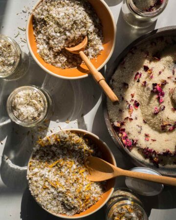 Several bowls of different salt mixes with wooden spoons.