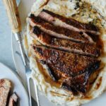 Seared ribeye over brown butter mashed potatoes with a roasting fork.