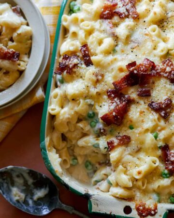 A close up of creamy baked carbonara mac and cheese.