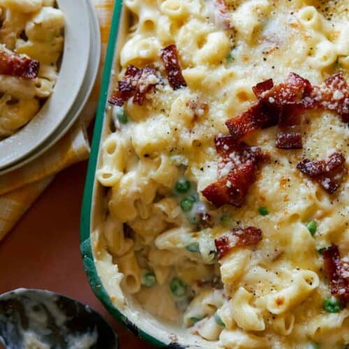 A close up of creamy baked carbonara mac and cheese.