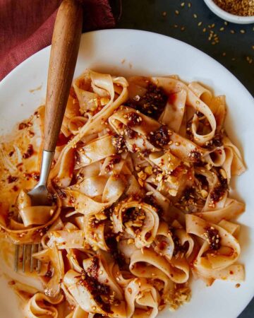 Chili oil garlic noodles on a plate twirled on a fork.