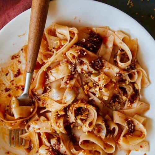 Chili oil garlic noodles on a plate twirled on a fork.