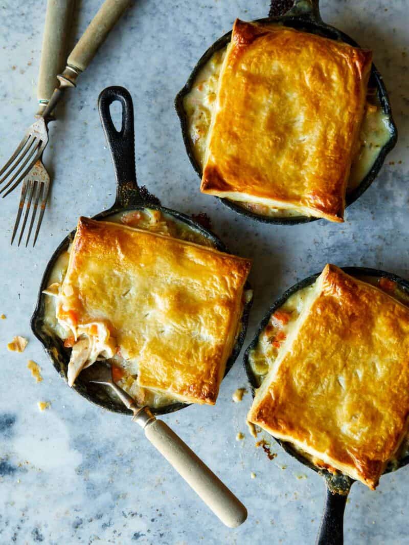 Chicken pot pies in individual skillets with forks.