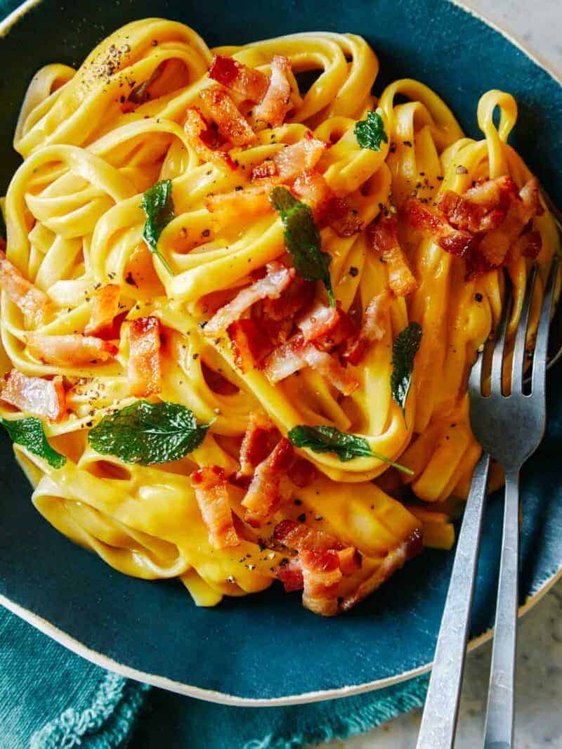 A close up of dairy free creamy butternut squash pasta with a fork.