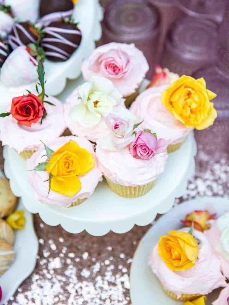 A cake stand with cupcakes covered in edible flowers.