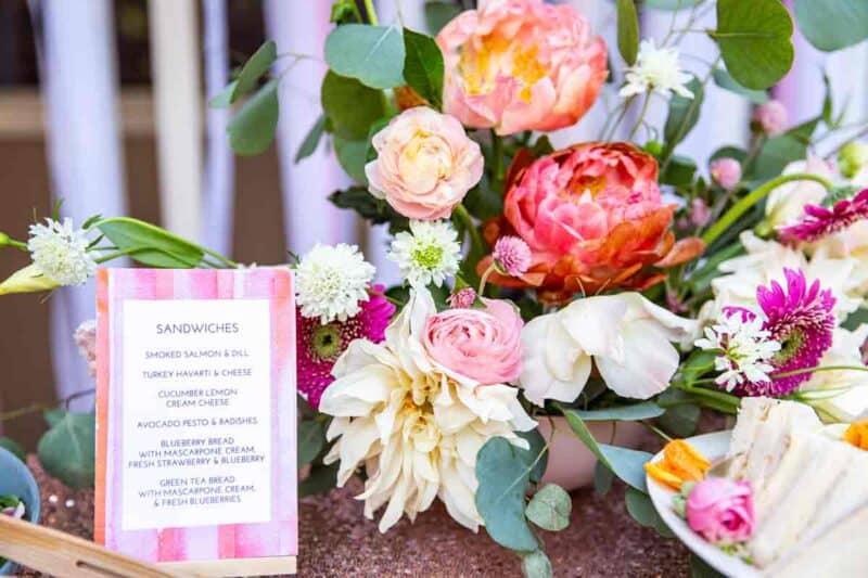 A vase of flowers next to a small sign.