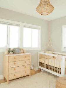 Nursery with light colored dresser and crib.