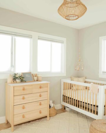 Nursery with light colored dresser and crib.