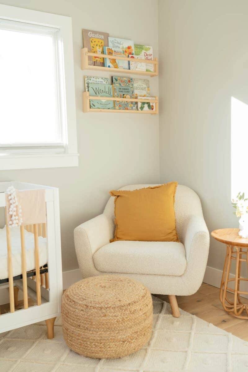 Corner of nursery with shelves and chair.