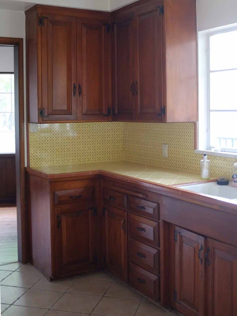 A kitchen sink with wooden cabinets and a window.