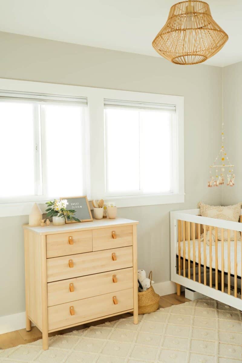 Nursery with light colored dresser and crib.