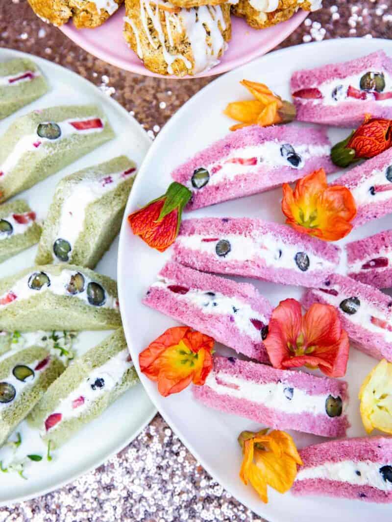 A close up of tea sandwiches with edible flowers.