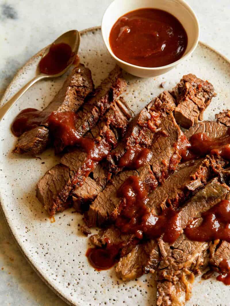 Slow cooked BBQ Wagyu Beef brisket with sauce and a spoon.