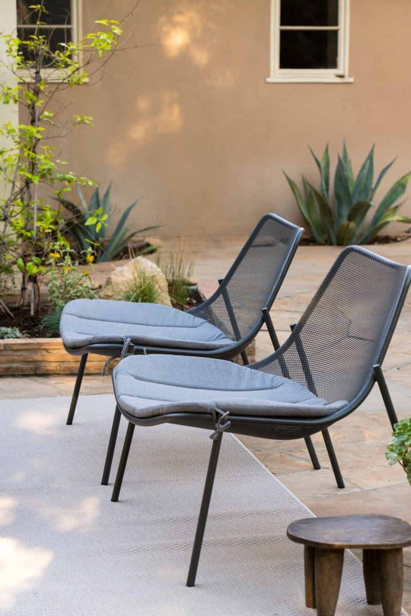 Two patio chairs with garden.