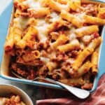 Baked Ziti in a blue pan with a spoon.