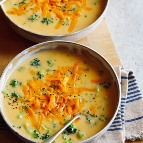 Bowls of broccoli cheddar soup with a spoon.