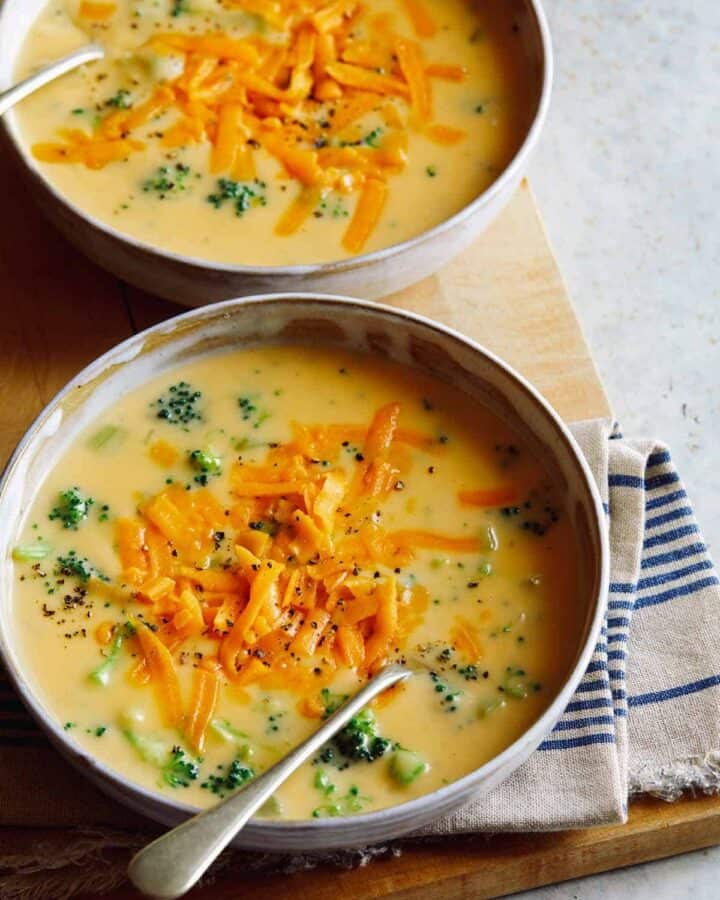 Bowls of broccoli cheddar soup with a spoon.