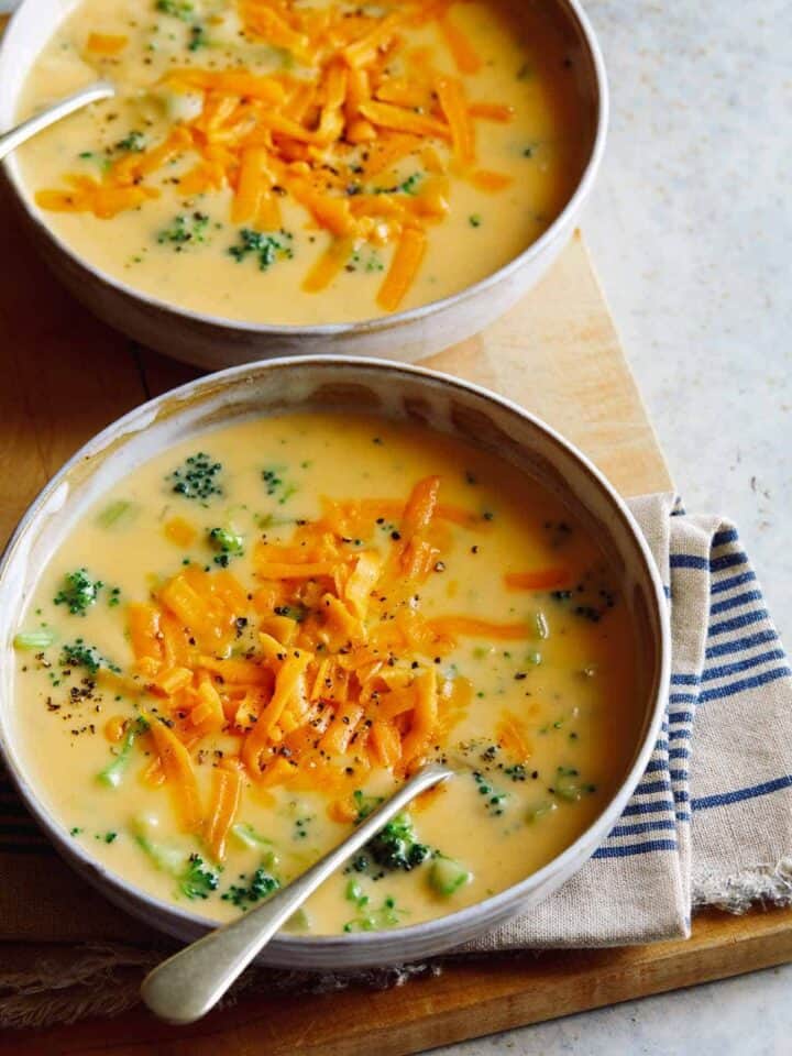 Bowls of broccoli cheddar soup with a spoon.