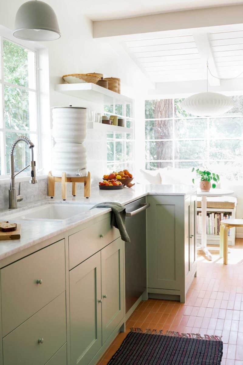 Kitchen sink by a window looking into eat in area.