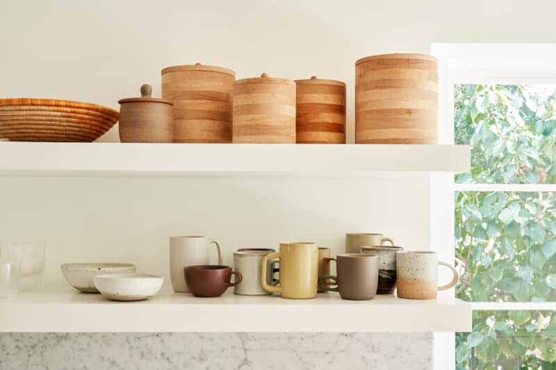 Floating shelves with a variety of containers and mugs.