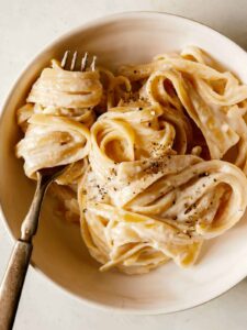 Fettuccine Alfredo in a bowl and twirled on a fork.