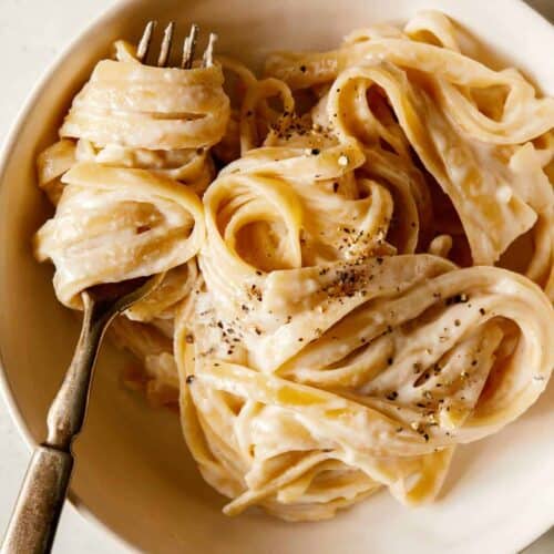 Fettuccine Alfredo in a bowl and twirled on a fork.