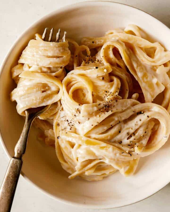Fettuccine Alfredo in a bowl and twirled on a fork.