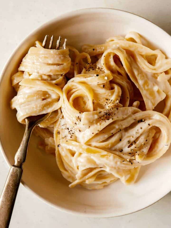 Fettuccine Alfredo in a bowl and twirled on a fork.