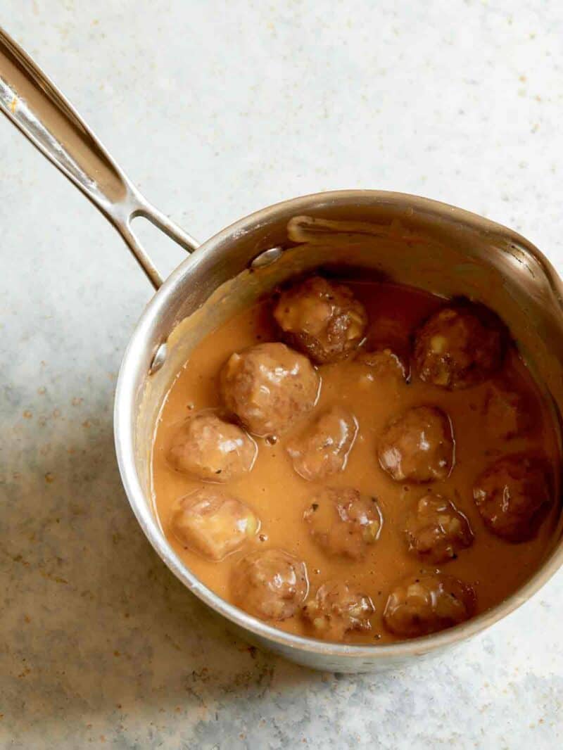 Lamb meatballs in a delicious gravy after being cooked in a pan, ready to be spooned on top of the egg noodles. 