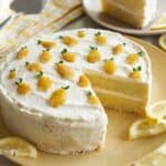 A whole lemon thyme cake with slice removed and served on a small plate.