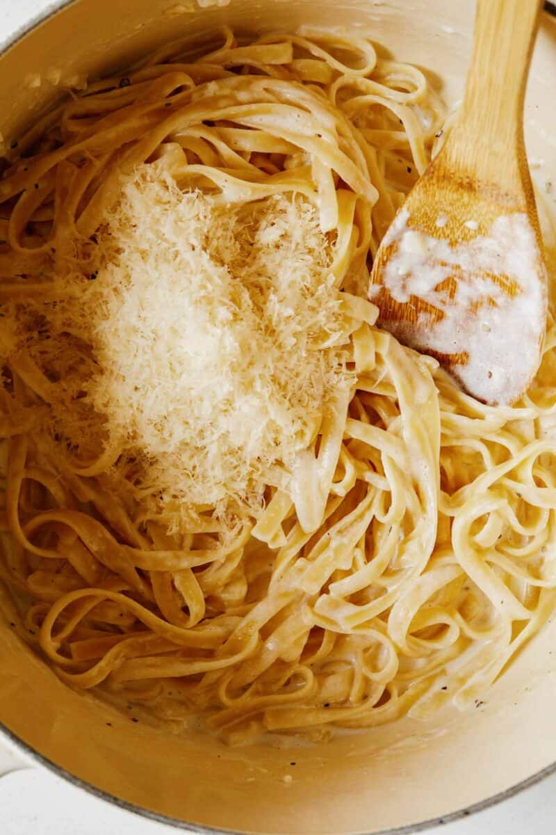 Fettuccine alfredo with fresh parmesan on top to be mixed in.