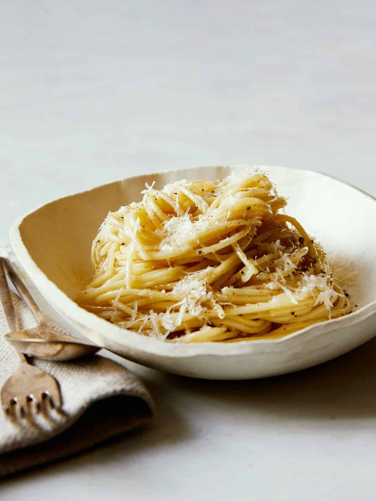 Bowl of Cacio e Pepe with a fork and spoon.