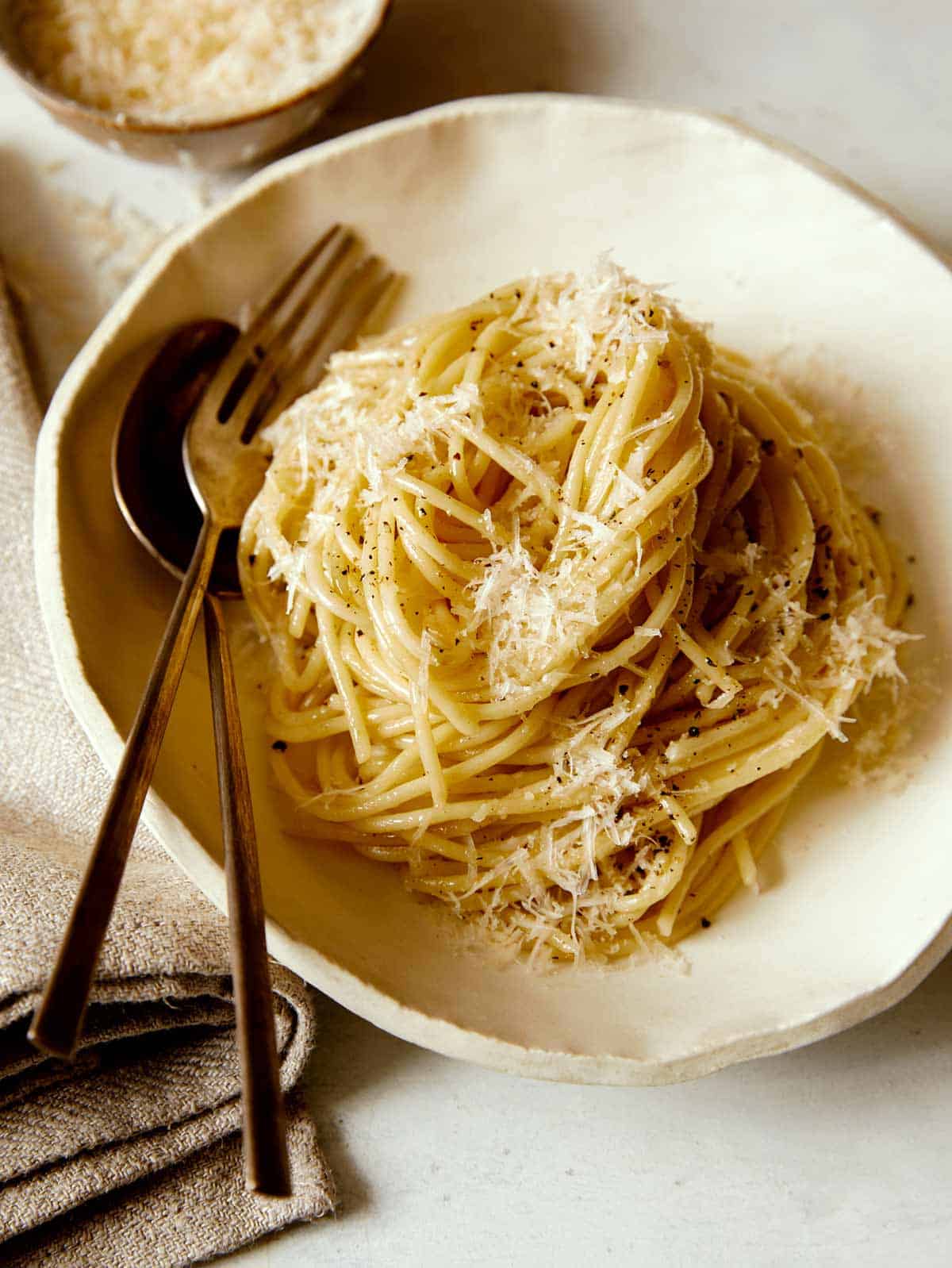 Bowl of Cacio e Pepe with a fork and spoon.