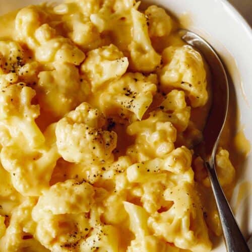 A close up of cauliflower mac and cheese with a spoon.