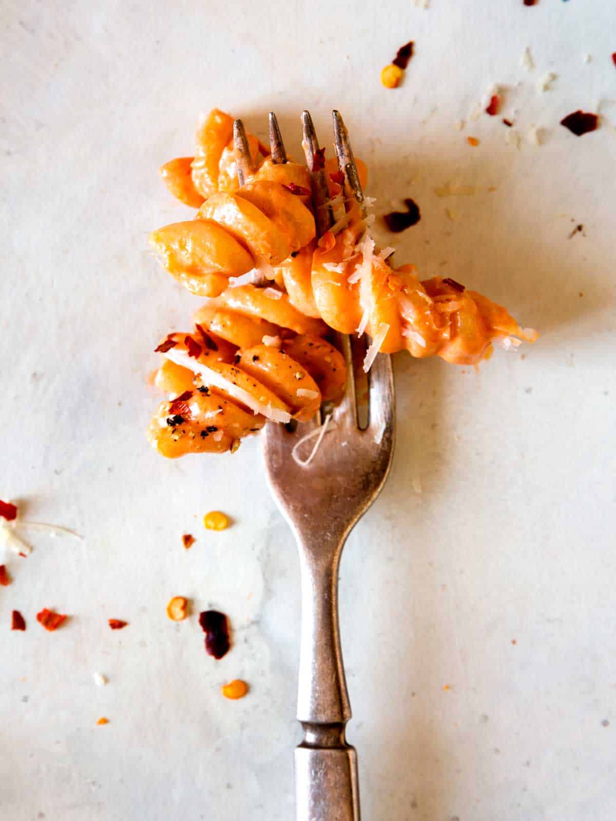 A close up of fusilli pasta with vodka sauce on a fork.