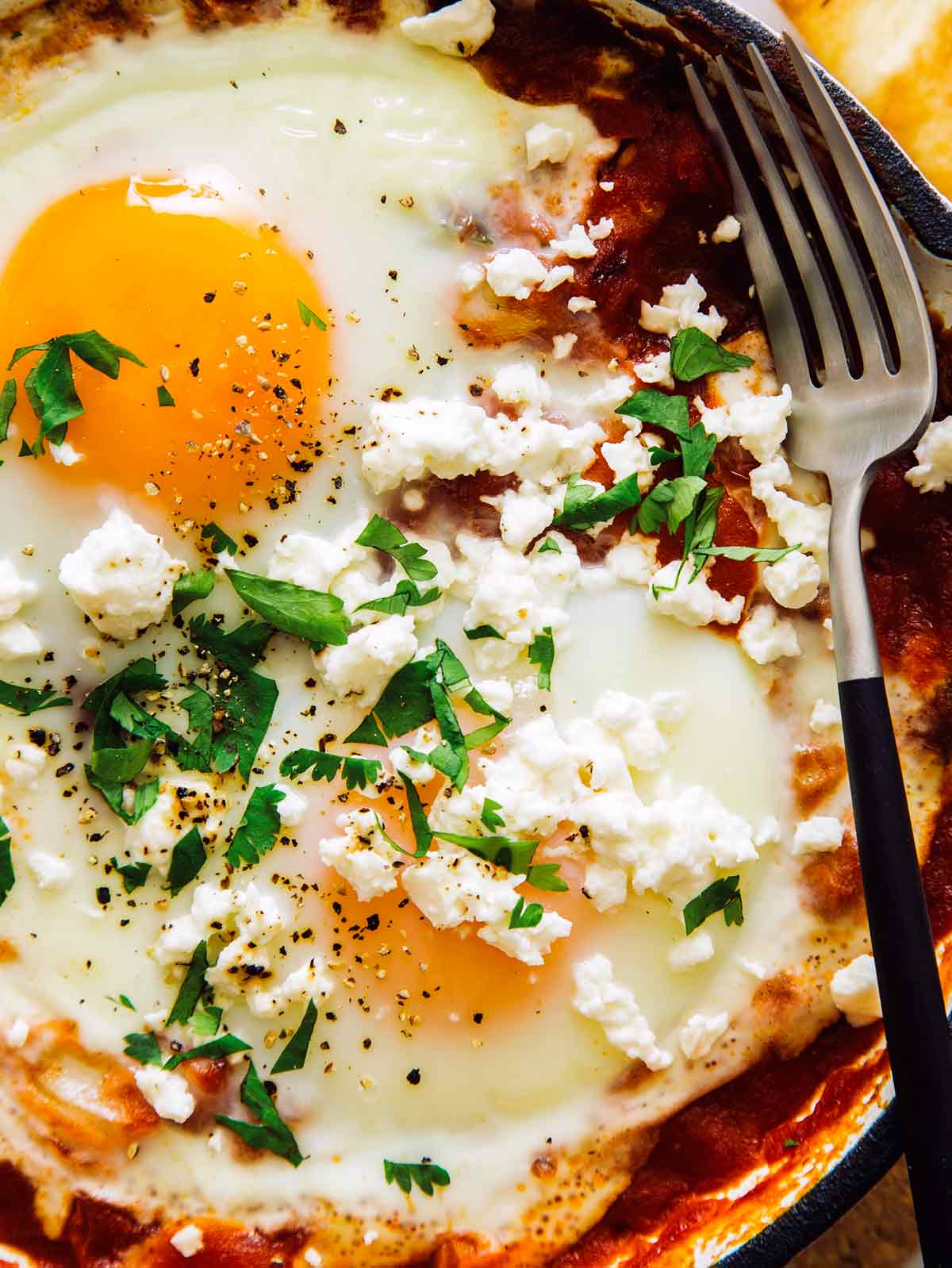 A close up image on the shakshuka recipe with feta and cilantro.