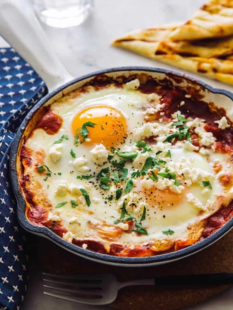 Shakshuka fresh out of the oven topped with cilantro and feta, ready to be served.
