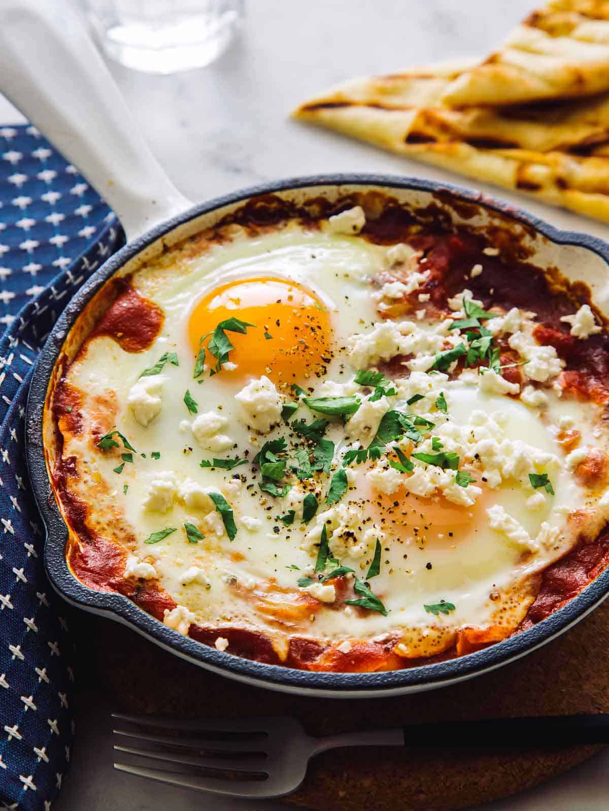 Shakshuka fresh out of the oven topped with cilantro and feta, ready to be served.