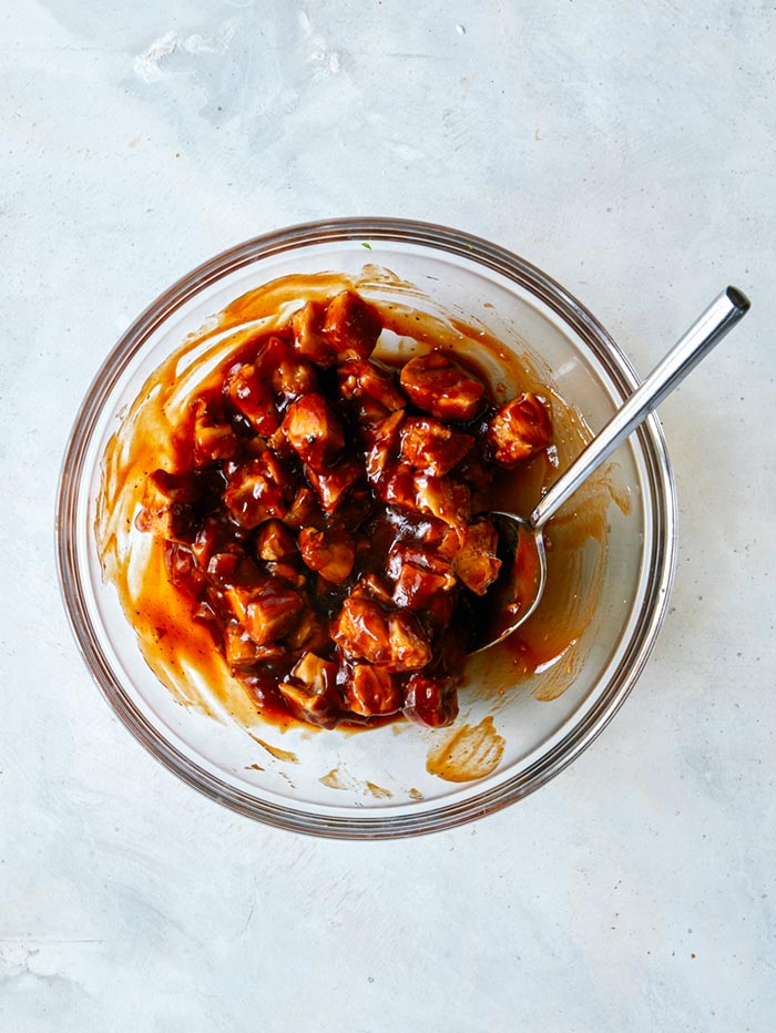 Chicken and BBQ sauce in bowl combined.