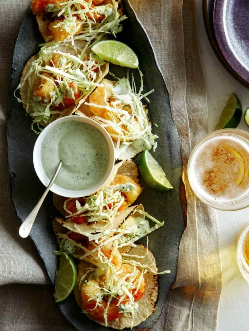 Beer Battered Shrimp Tacos on a platter with beer nearby.