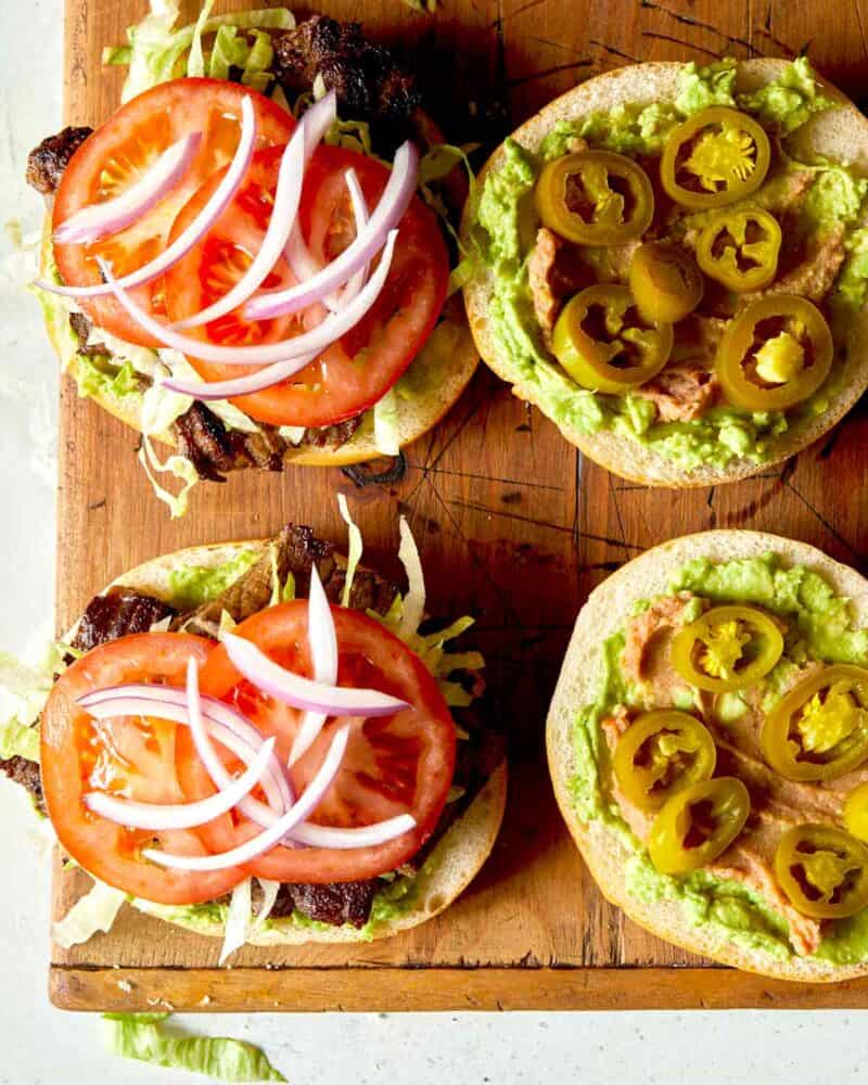 pickled jalapeno on a carne asada sandwich being made